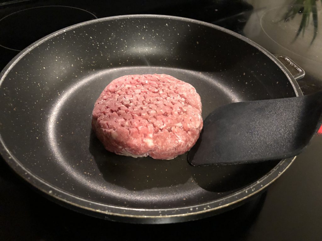 frozen burger cooking in skillet